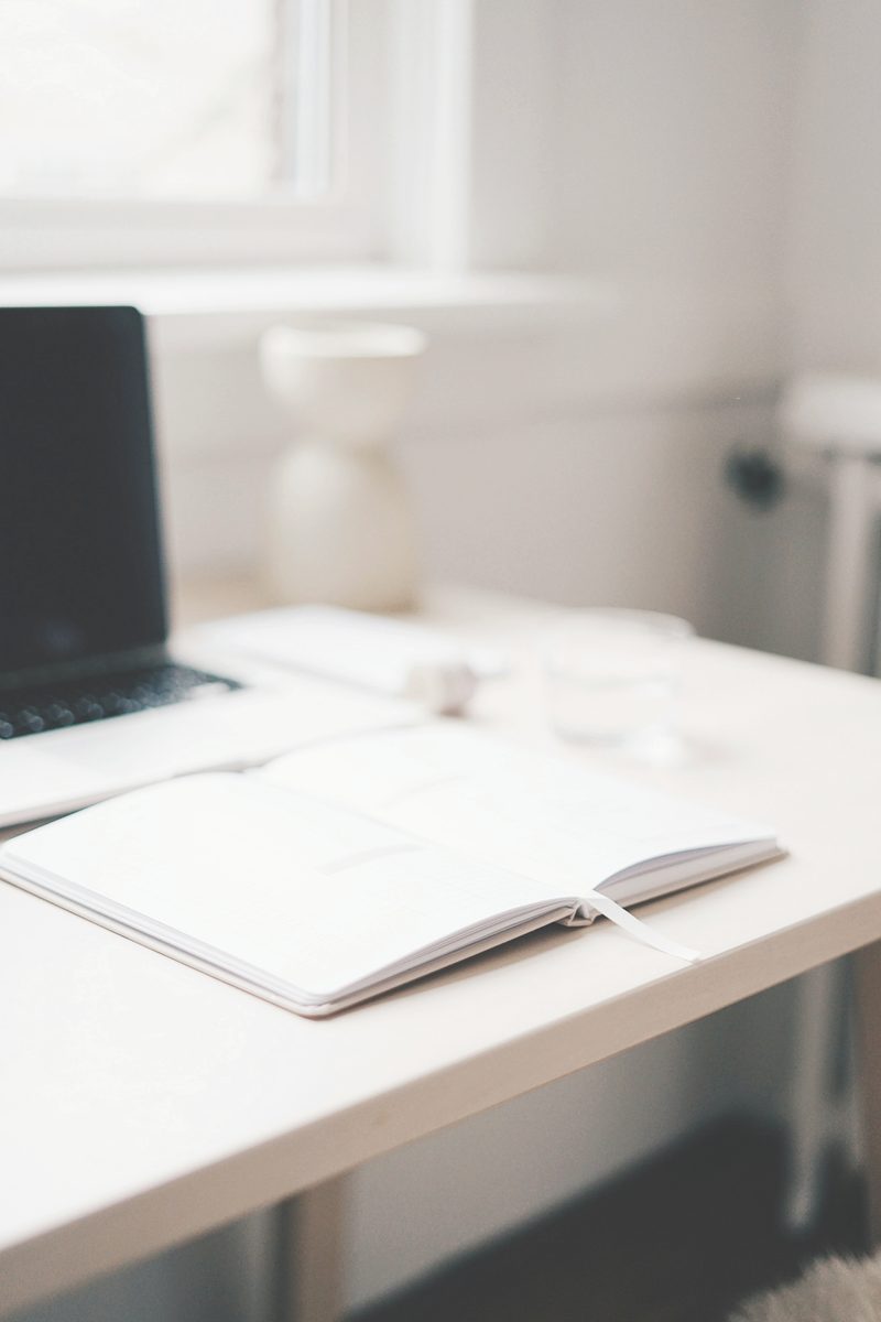 A calm desk with an open notebook, pen, and soft natural light