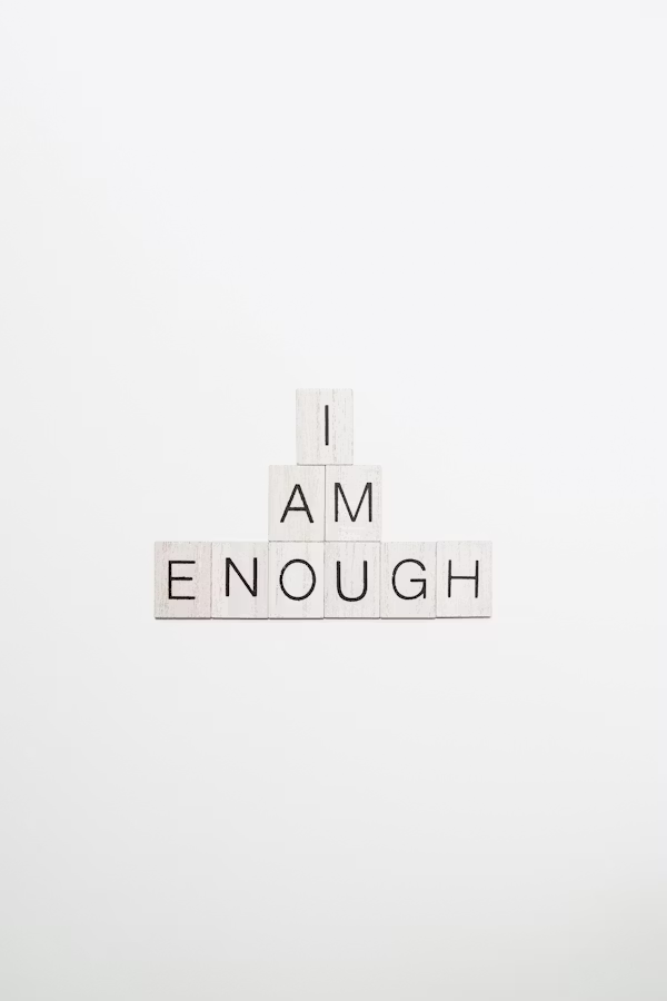 White letter tiles spelling the words I am enough
